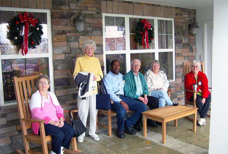Elderly people sitting on front porch