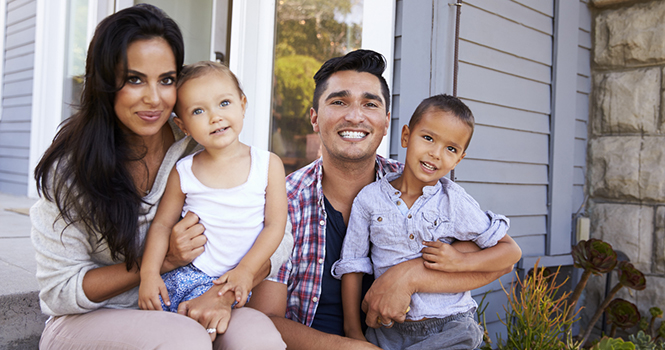 Portrait Of Family Sitting On Steps Outside Home